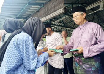 MOHAMMAD Nizar Jamaluddin memberikan duit raya kepada pengunjung yang hadir ke majlis Aidilfitri anjuran beliau di Ipoh hari ini. - UTUSAN/LIYANA RAMLI
