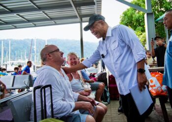 SAIFUDDIN Nasution Ismail beramah mesra bersama pelancong antarabangsa yang menggunakan perkhidmatan imigresen di Pelabuhan Telaga Harbour di Pantai Kok, Langkawi.