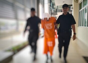 ANGGOTA polis mengiringi tertuduh semasa menghadiri prosiding perbicaraan di Mahkamah Pasir Mas, Kelantan. - UTUSAN/ROHANA ISMAIL