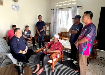 Akramuddin Abdul Aziz berbual dengan Rahim Kasim di Taman Perwira Cheng petang semalam. UTUSAN/AMRAN MULUP