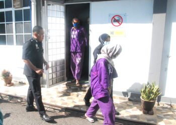 BEKAS pemandu bas ekspres serta teman wanitanya dibawa keluar selepas polis berjaya mendapatkan perintah tahanan reman selama empat hari di Mahkamah Majistret Jasin hari ini. - UTUSAN/AMRAN MULUP