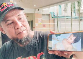 ABDUL Ghafar Masran menunjukkan gambar anaknya, Nur Kaisah Zahra yang sedang menerima rawatan dan dijadual menjalani pembedahan kedua minggu ini di Hospital Taiping. - UTUSAN/WAT KAMAL ABAS