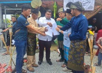 MUHAMMAD Arafat Varisai Mahamad (tiga dari kiri) menyerahkan salinan surat maklum balas penyelesaian isu banjir kilat kepada empat pengerusi persatuan penduduk taman perumahan di Kinding, dekat Ipoh semalam.