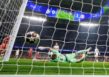 PENJAGA gol Real Madrid, Andriy Lunin gagal menyelamatkan pintu gawangnya selepas bolos buat kali kedua hasil percubaan penyerang Bayern Munich, Harry Kane yang berkesudahan Bayern menang 2-1 dalam aksi suku akhir pertama Liga Juara-Juara di Madrid, semalam. - AFP