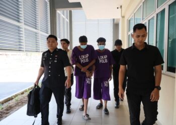 KEDUA-dua tertuduh diiringi polis semasa hadir untuk prosiding perbicaraan di Mahkamah Sesyen Pasir Mas, Kelantan.- UTUSAN/KAMARUL BISMI KAMARUZAMAN