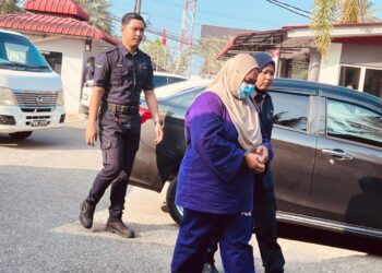 TERTUDUH diiringi polis semasa menghadiri prosiding perbicaraan di Mahkamah Majistret, Bachok, Kelantan.