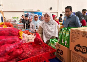 FUZIAH Salleh (dua dari kanan) memeriksa barangan yang dijual semasa Program Jualan Rahmah Madani di Dewan Serbaguna PPR di Kota Bharu, Kelantan. - UTUSAN/ROSLIZA MOHAMED