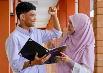 AHMAD Ateef Zhofran Abdul Majid (kiri) berkongsi kejayaan memperoleh keputusan cemerlang 10A dalam peperiksaan Sijil Pelajaran Malaysia (SPM) bersama Norfadilah Awang di Kuala Terengganu. - UTUSAN/PUQTRA HAIRRY