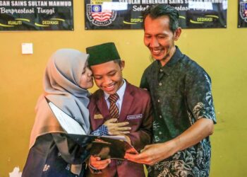 MUHAMMAD Nazirul Mubin Mohd. Yusof (tengah) berkongsi kejayaan memperoleh keputusan cemerlang Sijil Pelajaran Malaysia (SPM) bersama ibu dan bapanya. - UTUSAN/PUQTRA HAIRRY