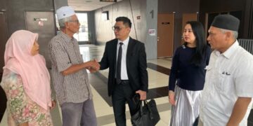 RUHANI Hussain (kiri) bersama suami bersyukur selepas Mahkamah Tinggi Kota Bharu, Kelantan menolak permohonan pihak defendan untuk membatalkan saman dan tuntutan yang difailkan oleh keluarga. -UTUSAN/ROSMIZAN RESDI