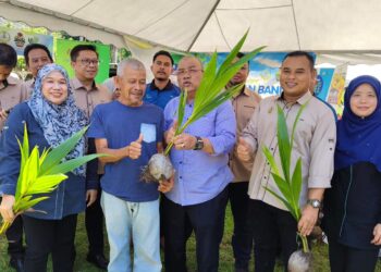 MOHD. Zolkafly Harun (tengah) menyampaikan anak pokok kelapa kepada orang ramai yang hadir pada program Jelajah Sejahtera Desaku@DUN Chenderoh di Dewan Arena Terbuka, Kampung Chuar Hulu, Padang Rengas hari ini.