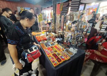 PENGUNJUNG membuat pilihan kraftangan tempatan untuk dibeli sebagai tanda kenangan pada hari terakhir sambutan perayaan Tadau Kaamatan di Hongkod Koisaan, Penampang, Kota Kinabalu, Sabah hari ini.-UTUSAN/HARDY JOE.