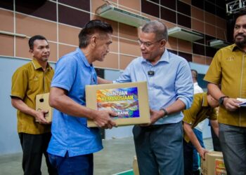 SAIFUDDIN Nasution Ismail menyerahkan sumbangan kepada mangsa ribut pada Program Sentuhan Budi Mangsa Ribut di Dewan Seri Serdang di Bandar Baharu, hari ini.