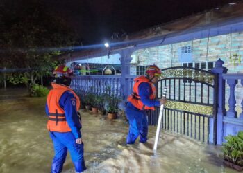 DUA anggota Angkatan Pertahanan Awam (APM) Daerah Kulim melakukan pemantauan di kawasan rumah penduduk yang terjejas banjir di Kulim. - IHSAN APM