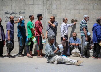 RAKYAT Palestin beratur mendapatkan hidangan panas di dapur amal yang dikendalikan oleh Program Makanan Sedunia (WFP) di kem pelarian Nuseirat di Gaza.- AFP