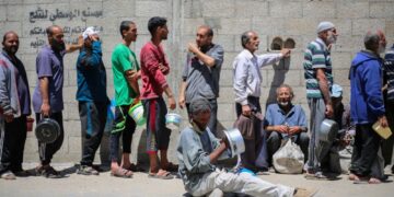 RAKYAT Palestin beratur mendapatkan hidangan panas di dapur amal yang dikendalikan oleh Program Makanan Sedunia (WFP) di kem pelarian Nuseirat di Gaza.- AFP