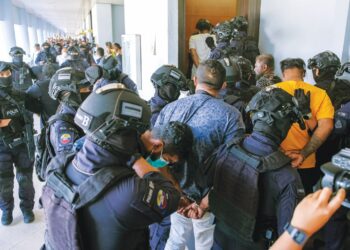 SEBAHAGIAN daripada 11 lelaki yang didakwa menjadi ahli kumpulan jenayah terancang RT6 dikawal ketat pihak polis ketika tiba di Kompleks Mahkamah Kuala Lumpur, semalam. – UTUSAN/M. FIRDAUS M. JOHARI