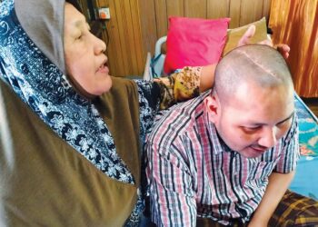 KAMARIAH Yusoff menunjukkan kesan pembedahan pada kepala anaknya semasa menerima kunjungan MTRK di rumahnya di Kampung Besut, Tumpat, Kelantan. 
– UTUSAN/ROHANA ISMAIL