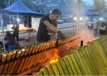 ADNAN Ibrahim memasak lemang Sarawak yang turut menerima tempahan pembeli dari Singapura.
