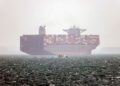 KAPAL kontena Hamouna berbendera Iran berlabuh ketika sebuah bot laju kecil melintasi Selat Hormuz berhampiran bandar Abbas di selatan Iran.- AFP