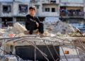SEORANG kanak-kanak lelaki duduk di atas runtuhan sebuah balai polis yang musnah diserang Israel di Gaza City.-AFP 