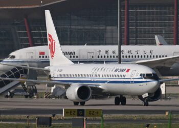 SEBUAH pesawat Air China Boeing 737 MAX 8 bergerak di landasan di hadapan sebuah Air China Boeing 787-9 Dreamliner di Lapangan Terbang Antarabangsa Beijing Capital di Beijing.- AFP