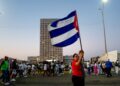 SEORANG wanita memegang bendera kebangsaan Cuba di sepanjang kawasan pantai Havana sempena Hari Pekerja Antarabangsa di hadapan Kedutaan AS di Havana pada 1 Mei lalu.- AFP