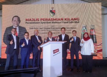 Aminuddin Harun (tengah) diiringi Mohd Roslan Mahayudin (tiga kiri) ketika menandatangani plak perasmian pembukaan kilang Mahsuri Food pada Majlis Perasmian Kilang Perusahaan Syarikat Mahsuri Food Sdn Bhd di Bandar Baru Enstek, Negeri Sembilan semalam. - UTUSAN/FAISOL MUSTAFA