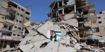 PENDUDUK Gaza melukis mural di atas runtuhan bangunan yang musnah semasa perang, di kem pelarian Shati di Gaza City.- AFP