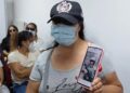 SEORANG wanita menunjukkan gambar suaminya warga Peru yang kini bertempur dalam perang di Ukraine semasa satu pertemuan di Lima.-AGENSI