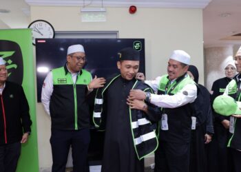 MOHD. Hisham Harun (kanan) menyarung vest Sahabat Maktab kepada seorang jemaah dalam Majlis Ramah Mesra dan Pelancaran Sahabat Maktab di Mekah semalam.