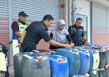 ROHAIDA Hassan (dua dari kanan) meninjau rampasan petrol di Pejabat KPDN Perlis, hari ini. -UTUSAN/IZLIZAN OTHMAN