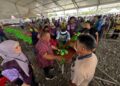 ABU Bakar Hamzah mengagihkan daging korban kepada penduduk bersempena program korban perdana DUN Kuala Perlis di Dataran Lok 9, Kuala Perlis hari ini.-UTUSAN