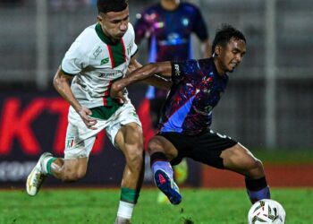 PEMAIN pertahanan Terengganu FC, Muhamad Alif Zakaria (kanan) mengawal bola daripada dirampas penyerang Kuching City FC, Ramadhan Saifullah Usman dalam aksi Liga Super di Stadium Negeri Sarawak semalam yang berkesudahan The Cats menang 2-1.- IHSAN KUCHING CITY FC
