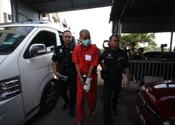 TERTUDUH dibawa ke mahkamah oleh pegawai penjara bagi menghadapi pertuduhan di Mahkamah Sesyen Sungai Petani. - UTUSAN/ SHAHIR NOORDIN