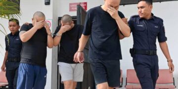 TIGA lelaki warga Korea Selatan diiringi polis ketika perbicaraan kes culik dan menahan rakan senegara di Mahkamah Sesyen Raub di Raub, Pahang  semalam.