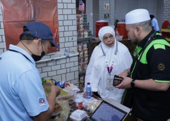 ZALIFAH Md. Alwi bersama seorang petugas haji ketika membeli makanan di Kafeteria Hotel Albraj Al-Janadriyah, Mekah.