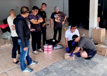 ANGGOTA polis memeriksa bungkusan yang mengandungi lebih 24,000 biji pil kuda dalam operasi sebuah syarikat kurier di bandar Narathiwat, Thailand.