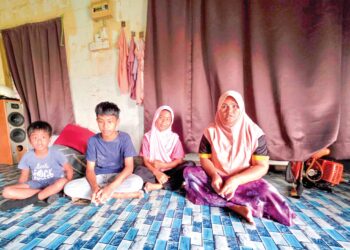 NORHAYATI Yusop bersama tiga anaknya yang tidak bersekolah ketika ditemui di Chikus dekat Pasir Salak. – UTUSAN/AIN SAFRE BIDIN