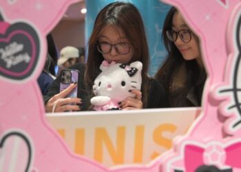 SEKUMPULAN gadis mengambil swafoto dengan produk watak Hello Kitty yang dicipta oleh syarikat Jepun Sanrio di sebuah pusat beli-belah di Beijing. – AFP