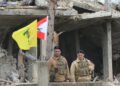 ASKAR berkawal di sebelah bendera Lubnan (kanan) dan Hizbollah (kiri) di luar sebuah bangunan yang musnah akibat pengeboman Israel di Tair Harfa. - AFP