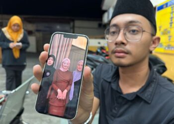 MUHAMMAD Faris Zulkifly menunjukkan gambar Allahyarham Nurfisya (tengah) ketika ditemui di Unit Forensik HRPZ II, Kota Bharu, Kelantan.