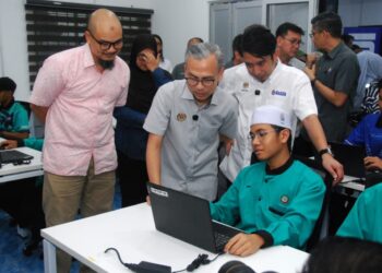 FAHMI Fadzil melihat pelajar menjalani pembelajaran selepas merasmikan NADI Telok Mas dan Penyerahan Watikah Pelantikan Pengerusi Panel Penasihat NADI Negeri Melaka di Taman Seri Telok Mas semalam. - UTUSAN/AMRAN MULUP