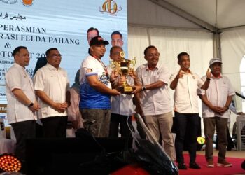 WAN Rosdy Wan Ismail (empat dari kanan) menyampaikan piala keseluruhan acara kepada belia Felda Wilayah Jengka sempena Himpunan Generasi Felda Pahang dan Felda Motor Fest 2 di Bandar Tun Abdul Razak Jengka di Maran, Pahang. - FOTO/SALEHUDIN MAT RASAD