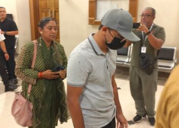 S. Vikneswaran berjalan keluar dari Mahkamah Sesyen di Kuantan, Pahang sambil diiringi ahli keluarga.