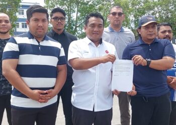 MOHD. Fakhrul Akhmal Mohamed  (depan tengah) bersama rakan-rakan menunjukkan laporan polis yang dibuat terhadap isu menghina Tengku Hassanal Ibrahim Alam Shah di hadapan IPD Pekan di Pekan, Pahang.