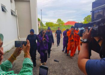 PASANGAN suami isteri (depan) dibawa oleh polis untuk mendapatkan perintah reman di Mahkamah Kota Bharu, Kelantan hari ini-UTUSAN/YATIMIN ABDULLAH.