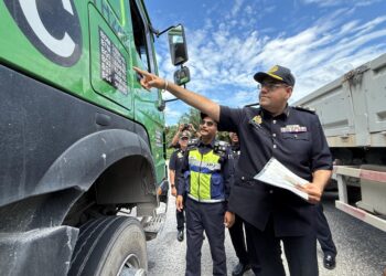 JASYINDAR Singh Sihdu (kanan) memeriksa sebuah lori yang dikesan membawa lebih muatan di Nilai, Seremban, hari ini. - UTUSAN/NOR SHAFIQAH MOHD. GHAZALI.