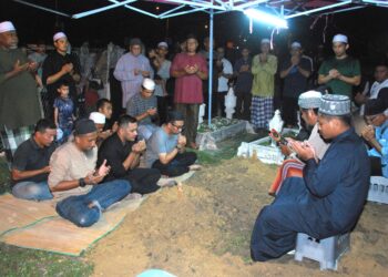 AHLI keluarga Allahyarham Ahmad Fiqri Zakaria mengaminkan doa ketika pengebumian di Tanah Perkuburan Islam Padang Sebang, Gadek, Melaka. - UTUSAN/AMRAN MULUP