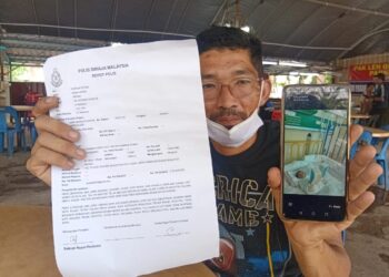 MUHAMMAD Nor Fadly Mohd Shaidi menunjukkan laporan polis dan gambar bayi lelakinya yang mengalami kecederaan patah tulang paha semasa ditemui di Sungai Petani, hari ini.